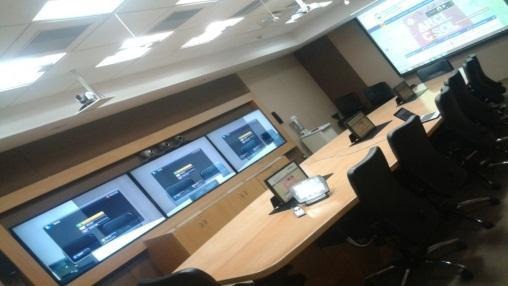 A room with a large screen
AI-generated content may be incorrect.